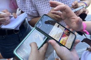 Grupo de amigas consultando una pista de la gincana en el móvil durante la despedida de soltera
