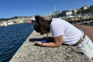 Participante de la gincana anotando la solución de una prueba junto al puerto de Vigo